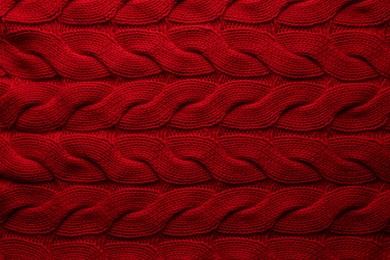 Beautiful red knitted fabric as background, top view