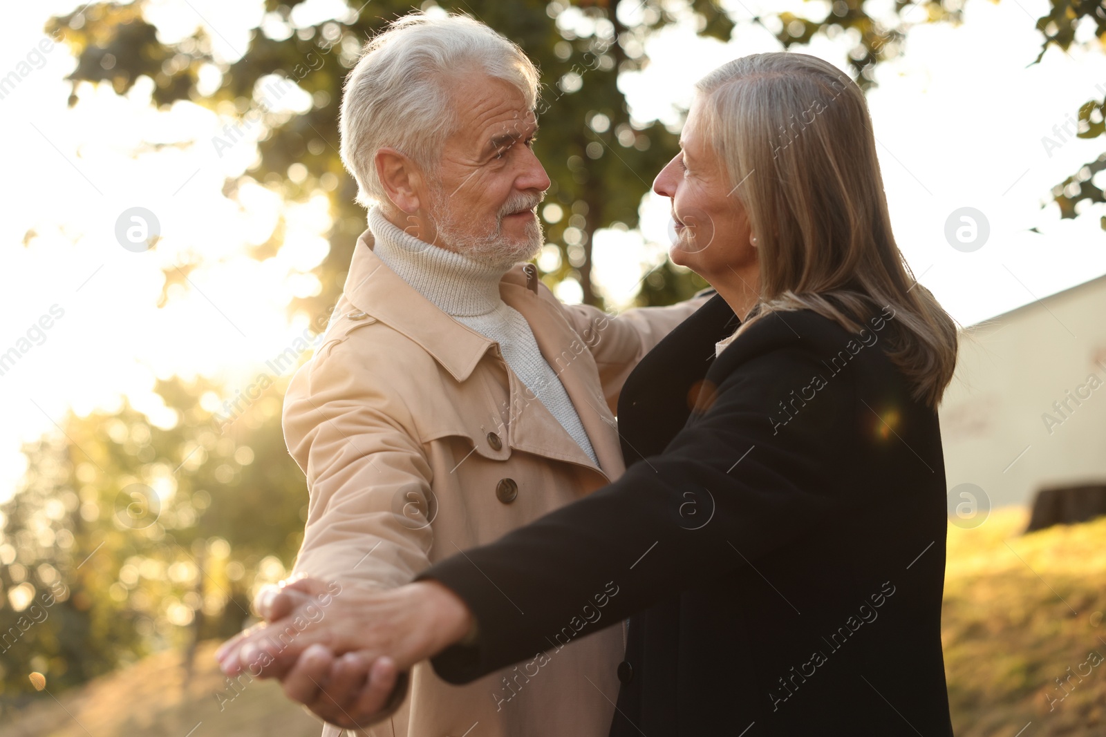 Photo of Affectionate senior couple dancing together outdoors. Romantic date