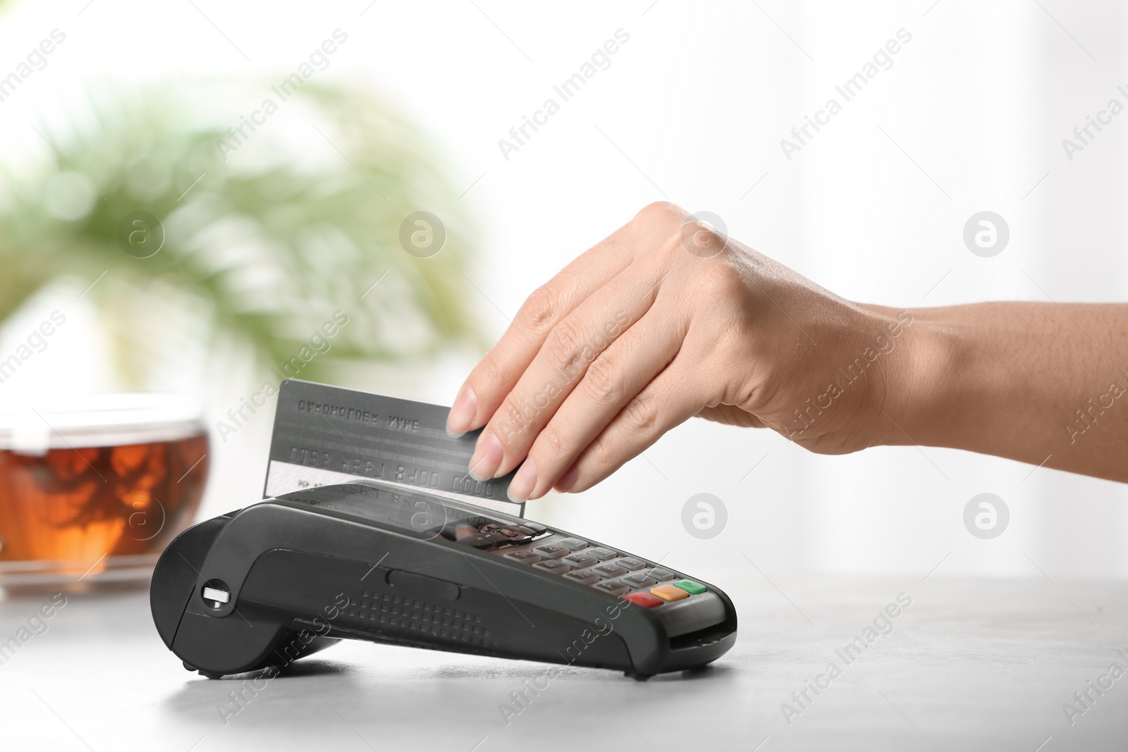 Photo of Woman using terminal for credit card payment in cafe