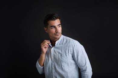 Portrait of handsome young man on black background