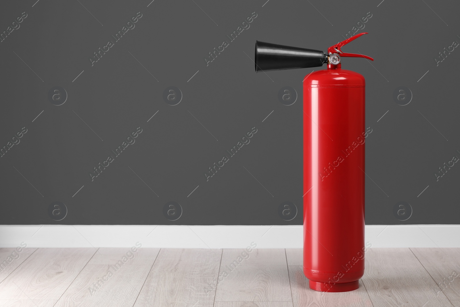 Photo of Fire extinguisher near grey wall, space for text