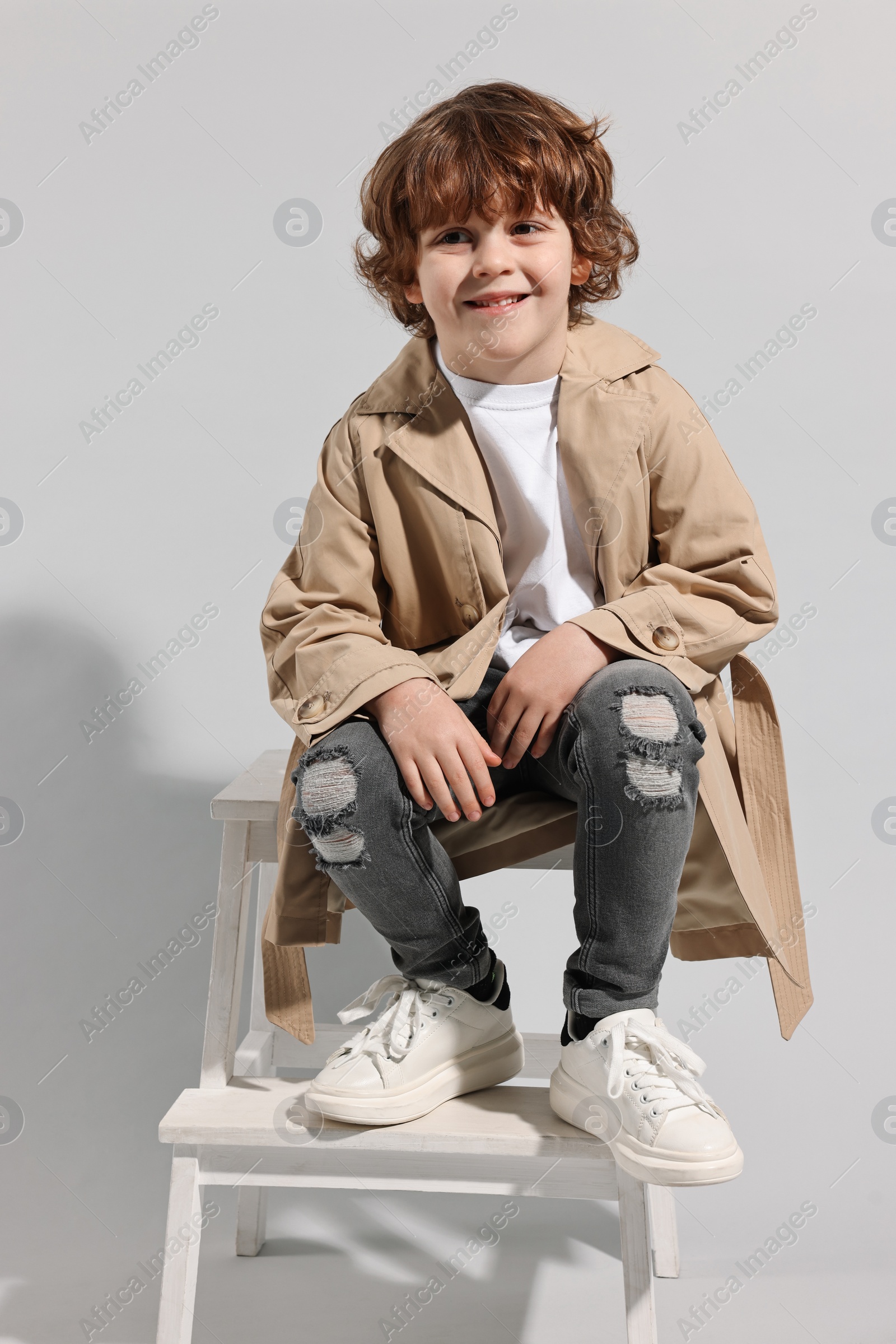 Photo of Fashion concept. Stylish boy posing on light grey background