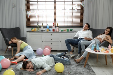 Photo of Group of friends sleeping in messy room after party