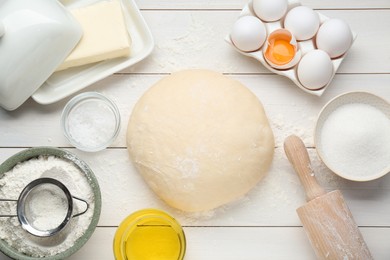 Fresh yeast dough and ingredients on white wooden table, flat lay