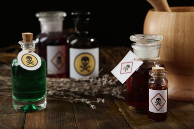 Photo of Bottles with different poisons on wooden table