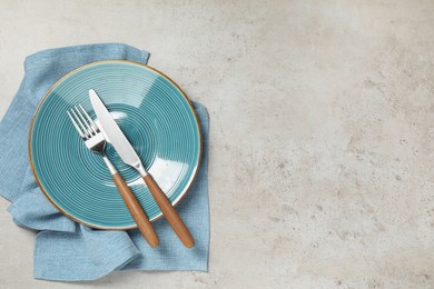 Setting with beautiful cutlery on textured table, top view. Space for text