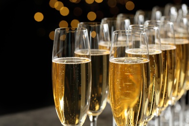 Photo of Many glasses of champagne on blurred background, closeup