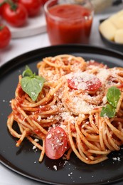 Tasty pasta with tomato sauce, cheese and basil on white table, closeup