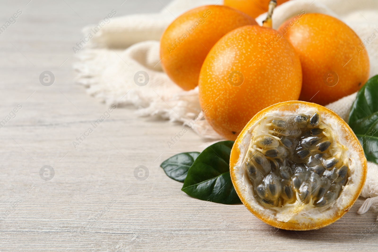 Photo of Delicious ripe granadillas on white wooden table, closeup. Space for text