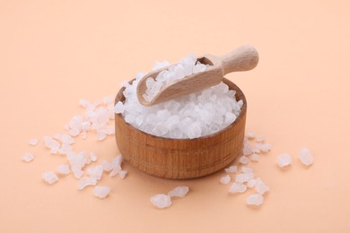 Photo of Bowl and scoop with sea salt on beige background, closeup