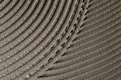 Lined grey concrete as background, top view. Tile installation