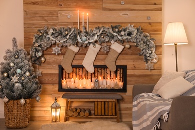 Photo of Festive room interior with decorative fireplace and Christmas stockings