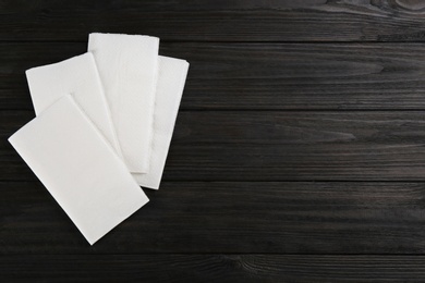 Photo of Clean napkins on wooden table, flat lay. Space for text