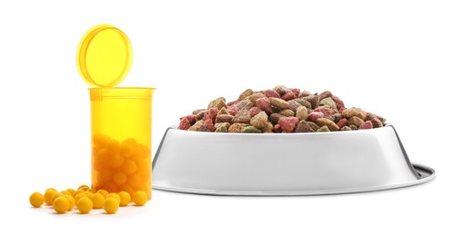 Image of Dry pet food in feeding bowl and bottle with vitamin pills on white background