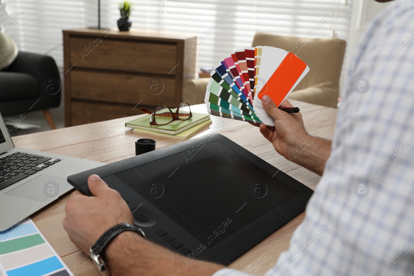 Photo of Professional designer with graphic tablet at wooden table, closeup