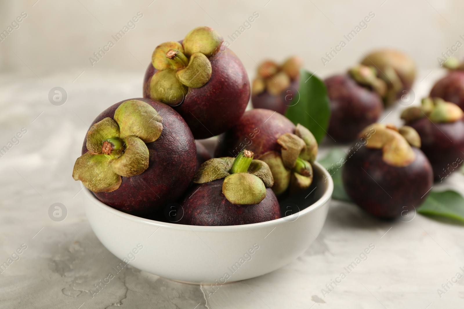 Photo of Fresh ripe mangosteen fruits on light grey table