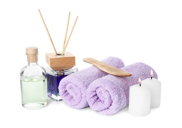 Photo of Spa composition. Towels, essential oil, reed air freshener, burning candles and spatula on white background