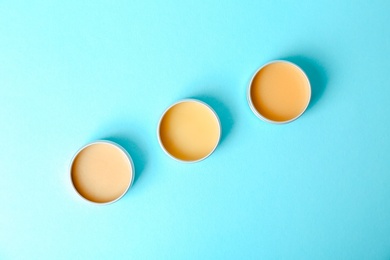 Photo of Flat lay composition with lip balms on color background