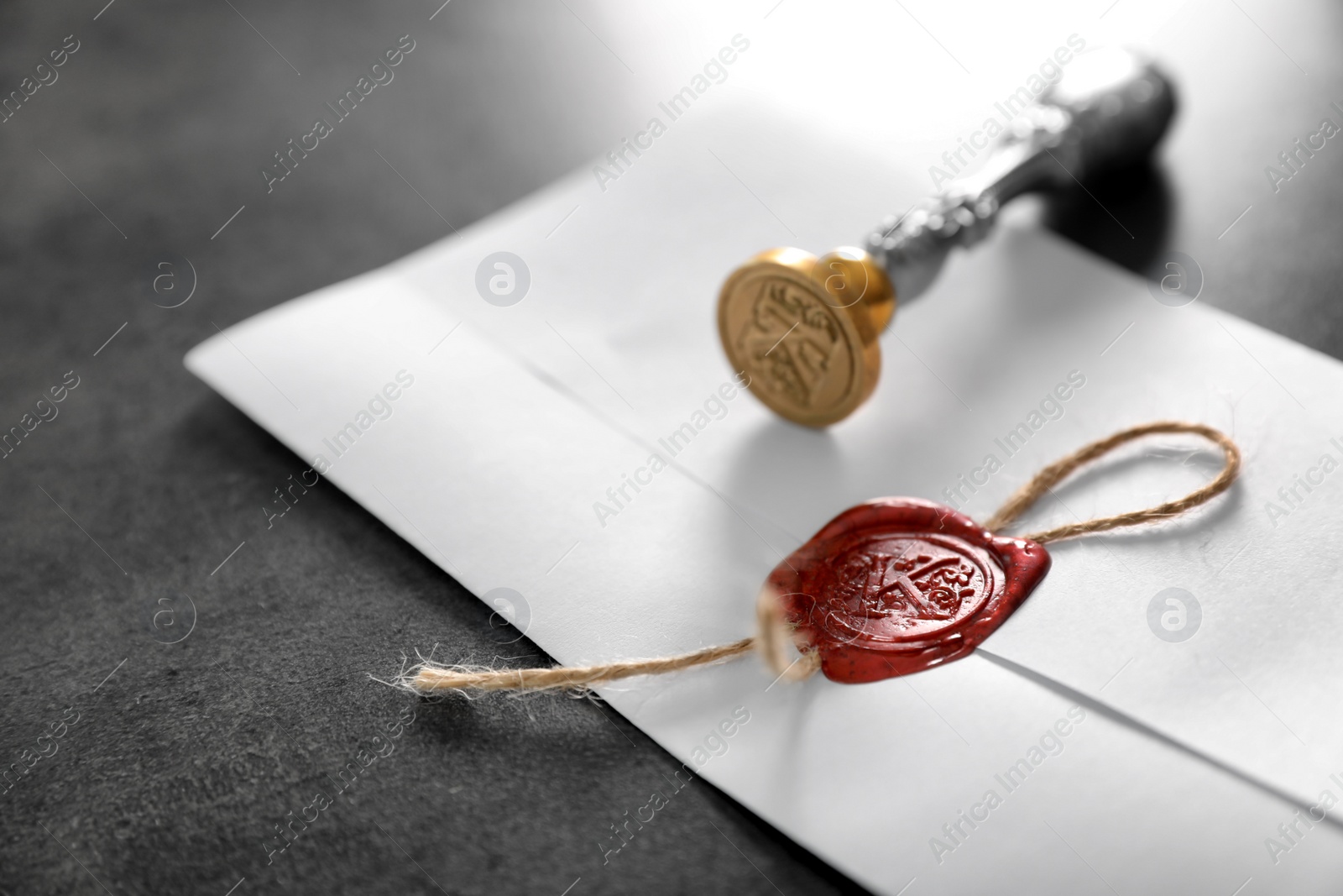 Photo of Vintage notary stamp and sealed document on grey background, closeup