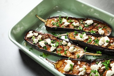 Photo of Baking dish with fried eggplant slices on grey background, closeup