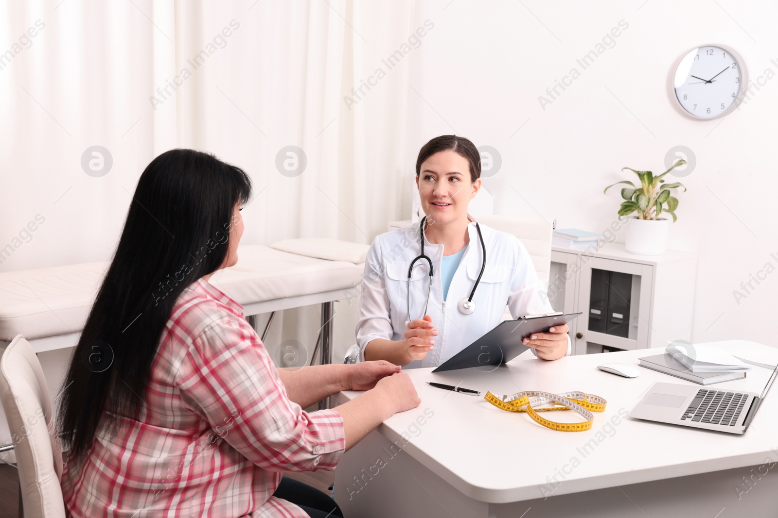 Photo of Overweight woman consulting with nutritionist in clinic