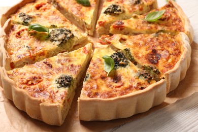 Delicious homemade vegetable quiche on white wooden table, closeup