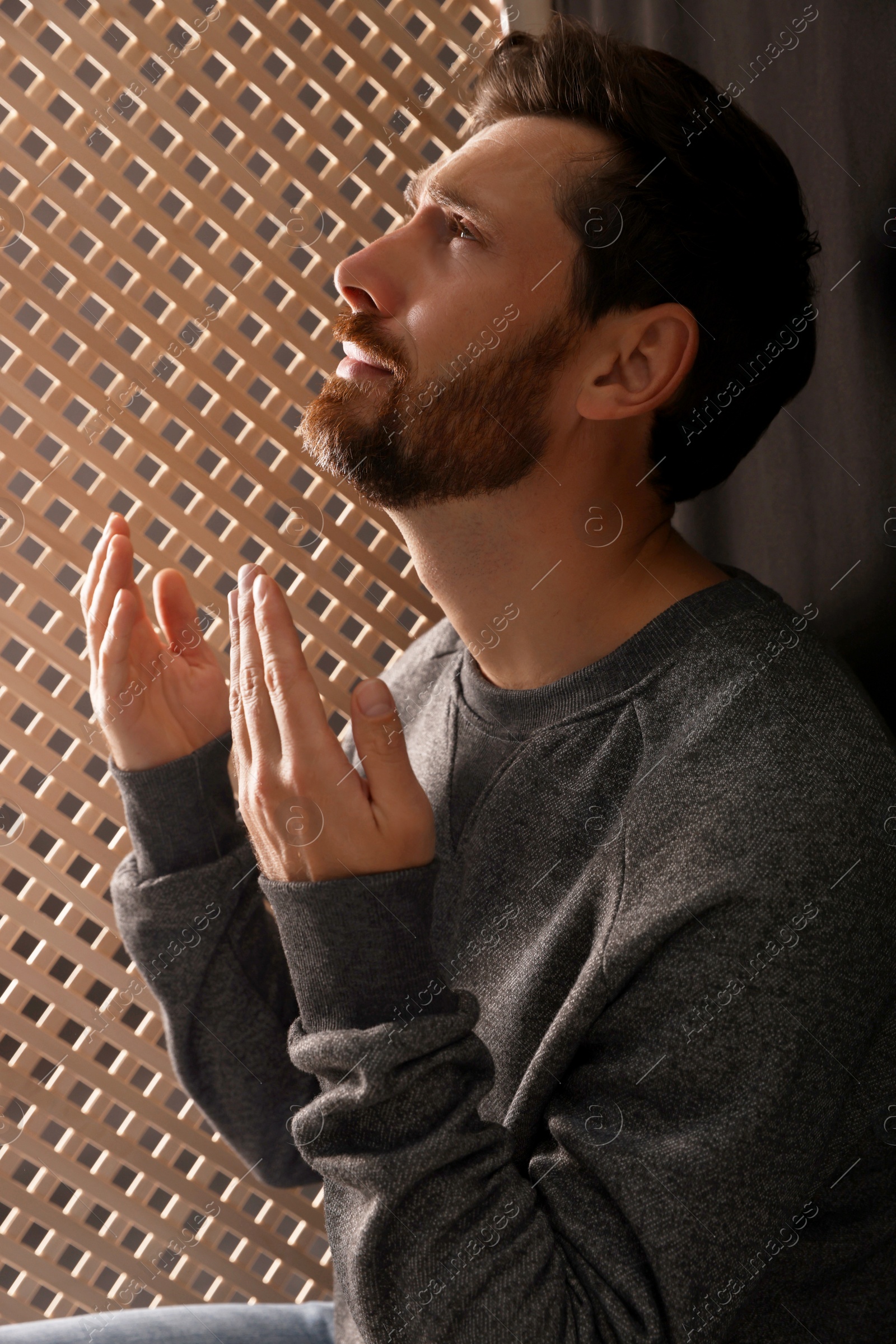 Photo of Man praying to God during confession in booth