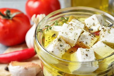 Pickled feta cheese in jar on table, closeup