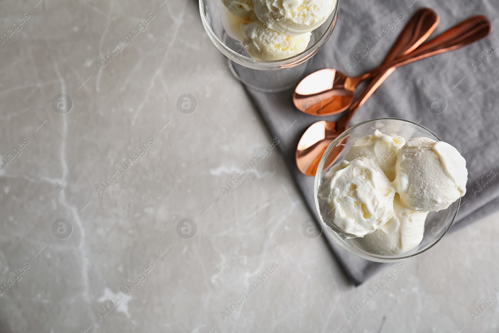 Photo of Bowls with tasty vanilla ice cream on grey background, top view