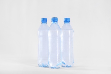 Photo of Plastic bottles with pure water on white background