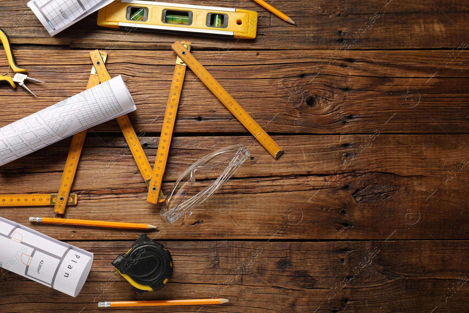 Photo of Flat lay composition with building level and other construction tools on wooden table, space for text