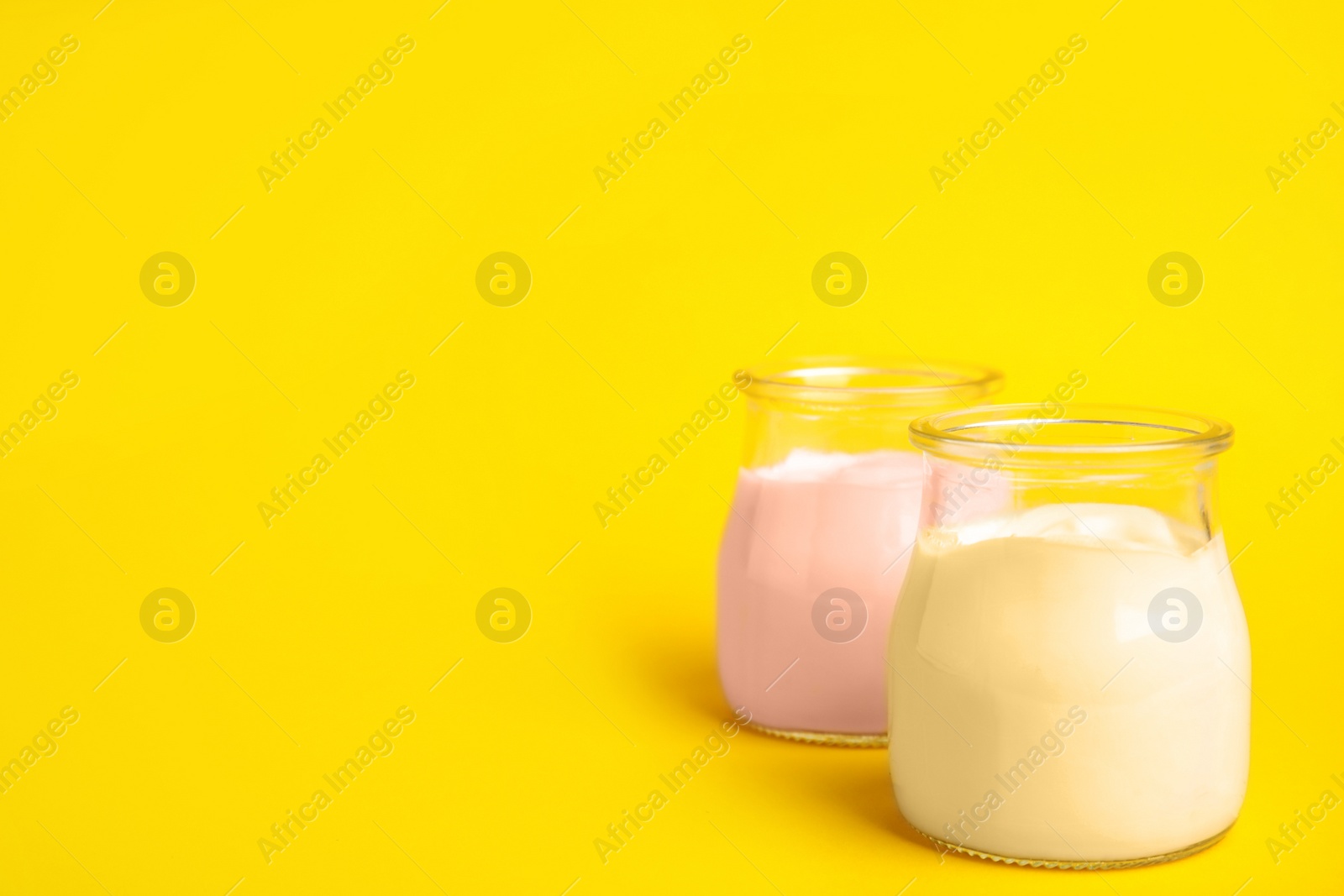 Photo of Tasty organic yogurt on yellow background. Space for text