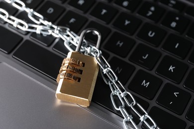 Photo of Cyber security. Padlock with chain on laptop, closeup