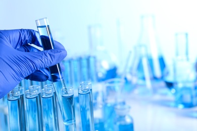 Photo of Doctor holding test tube with sample for analysis in laboratory, closeup