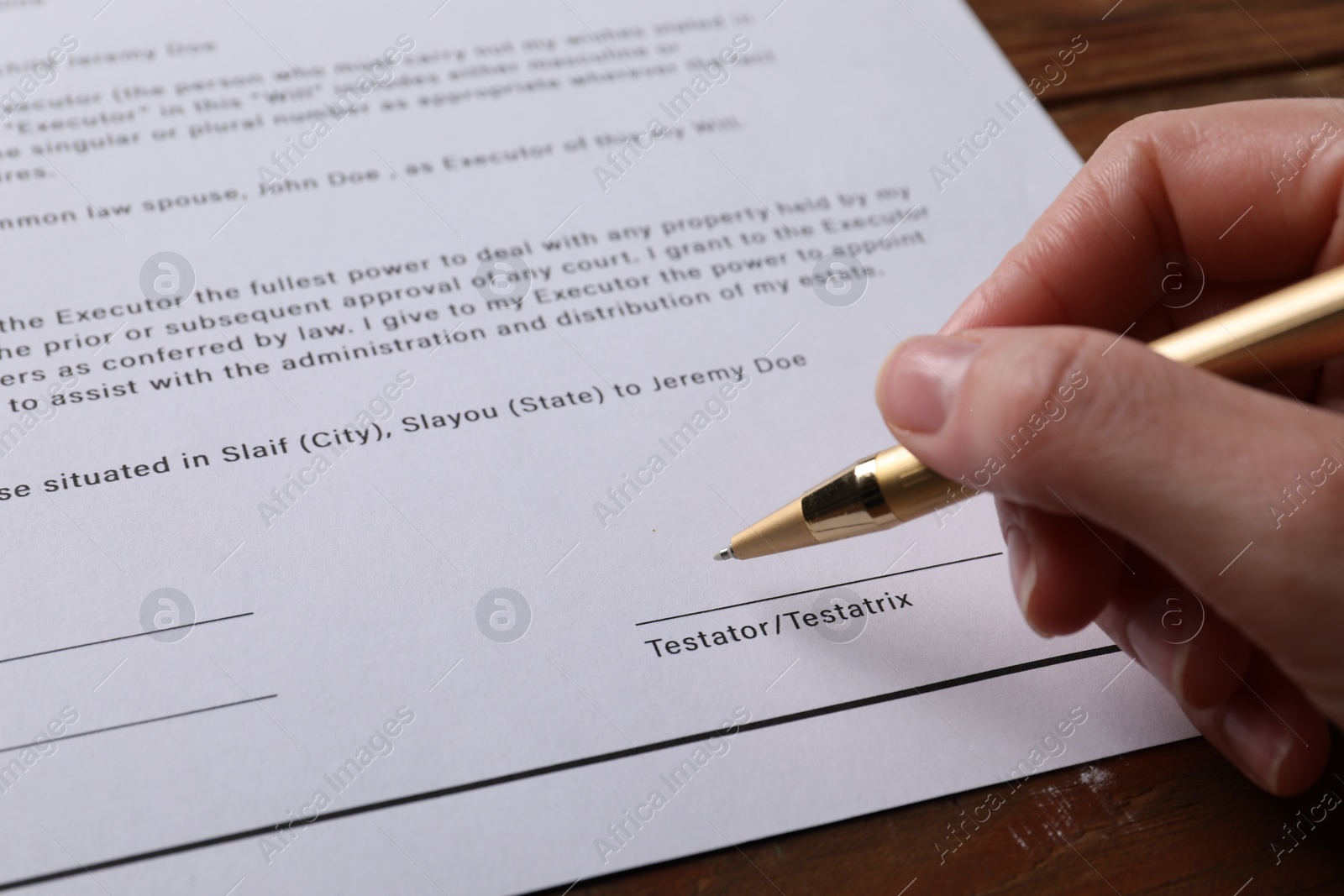 Photo of Woman signing Last Will and Testament at wooden table, closeup