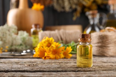 Photo of Bottle of essential oil on wooden table, space for text. Medicinal herbs