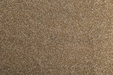 Photo of Shiny light brown glitter as background, closeup