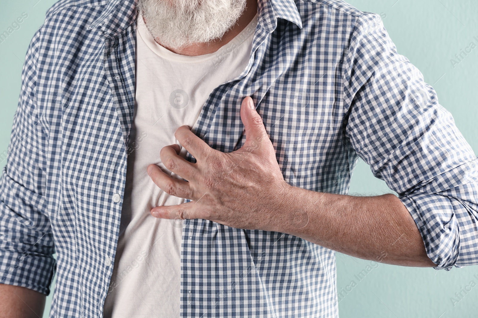 Photo of Mature man having heart attack, closeup