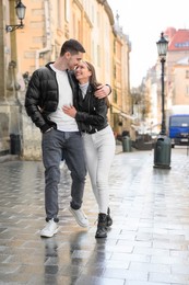 Lovely young couple walking together on city street. Romantic date