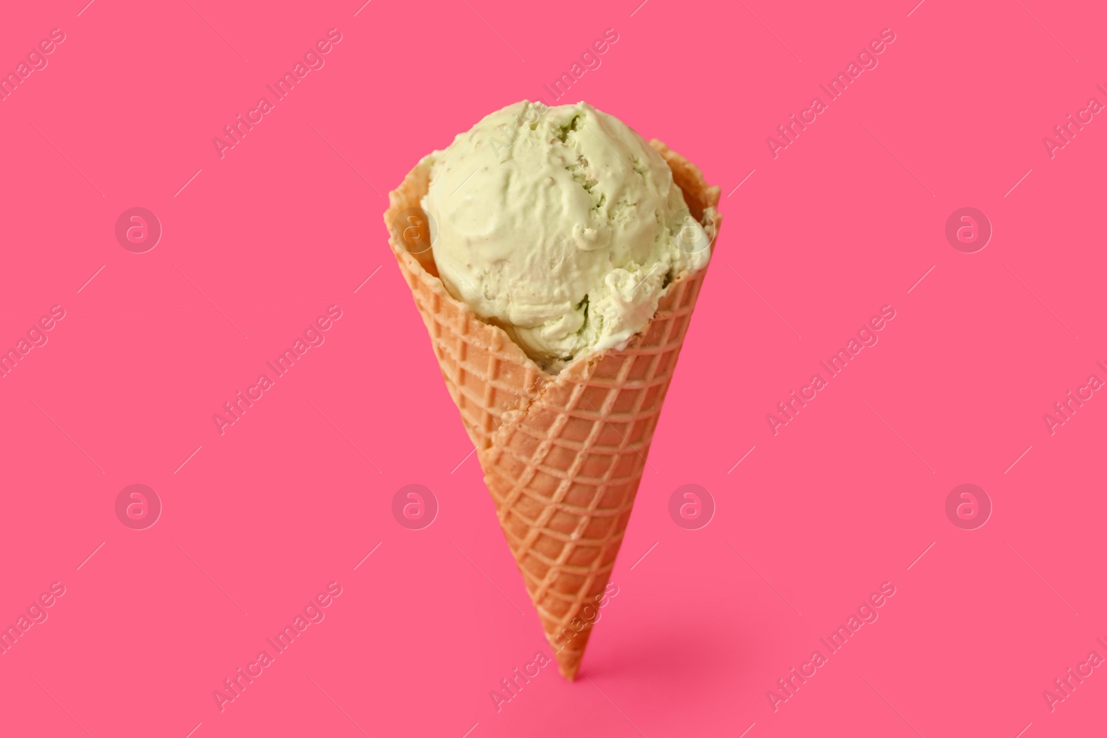 Photo of Delicious ice cream in waffle cone on pink background