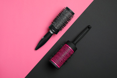 Photo of Modern round hair brushes on color background, flat lay