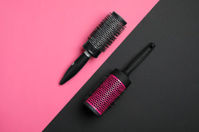 Modern round hair brushes on color background, flat lay