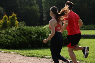 Healthy lifestyle. Couple running outdoors on sunny day, space for text