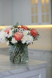 Vase with beautiful flowers on table in kitchen. Interior design