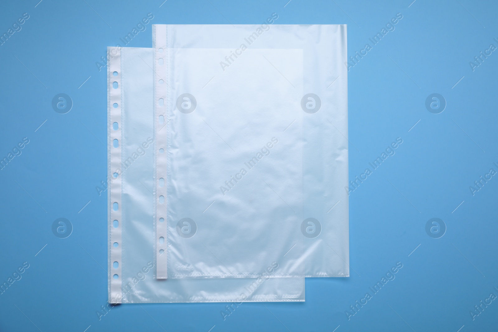 Photo of Punched pockets on light blue background, flat lay