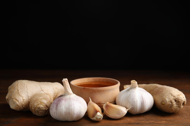 Photo of Fresh garlic and other natural cold remedies on wooden table. Space for text