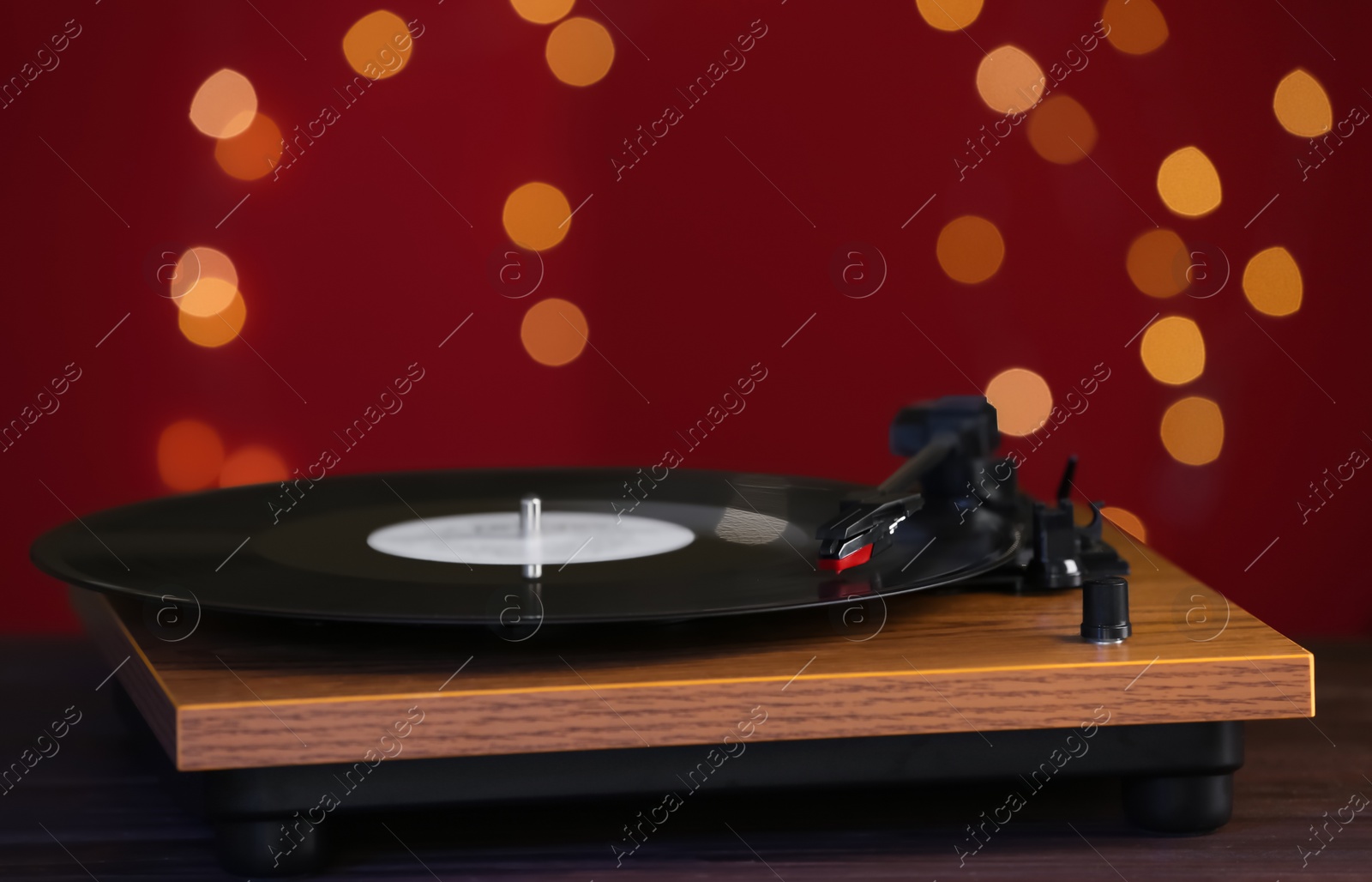 Photo of Turntable with vinyl record against blurred lights. Space for text