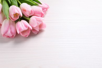 Photo of Beautiful pink spring tulips on white wooden background, space for text