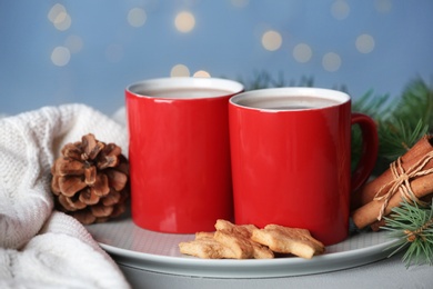 Composition with cups of tasty cocoa on table against blurred lights