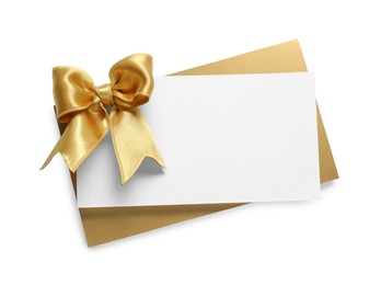 Photo of Blank gift card with golden bow isolated on white, top view